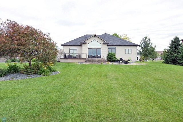 4703 Woodhaven St S, Fargo, ND 58104 - rear view of property featuring a lawn, a patio area, a shingled roof, and a wooden deck