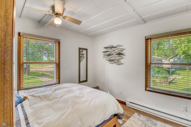 27096 Little Floyd Lake Rd Unit 8, Detroit Twp, MN 56501 - bedroom featuring a baseboard heating unit, wood finished floors, and ceiling fan