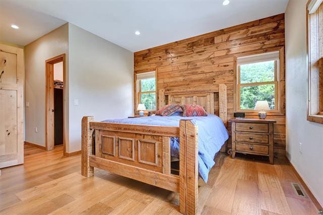 12207 Railroad Rd, Lake Nebagamon, WI 54849 - bedroom with light wood-style flooring, multiple windows, recessed lighting, and wooden walls
