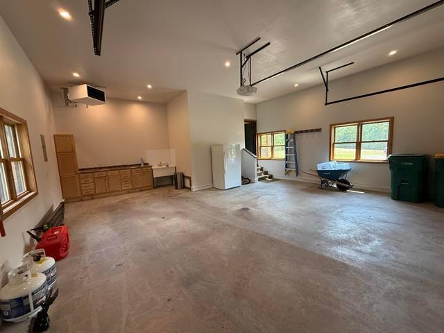 12207 Railroad Rd, Lake Nebagamon, WI 54849 - garage featuring freestanding refrigerator, recessed lighting, and a garage door opener