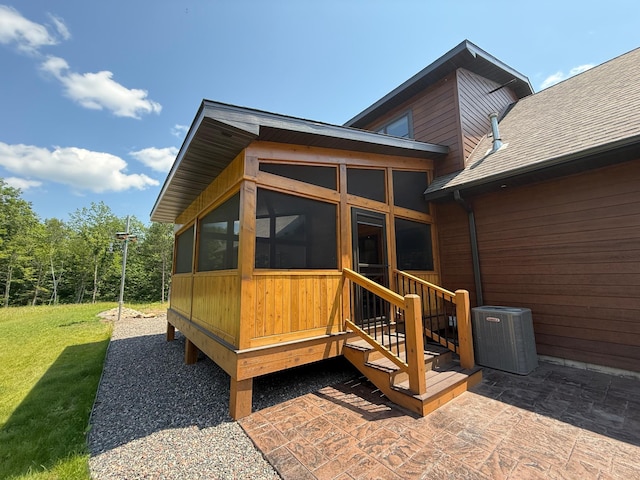 12207 Railroad Rd, Lake Nebagamon, WI 54849 - rear view of property featuring a sunroom, a shingled roof, and a lawn