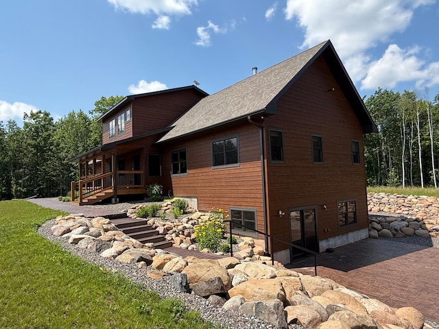 12207 Railroad Rd, Lake Nebagamon, WI 54849 - rear view of house featuring a deck, a patio area, a shingled roof, and a yard