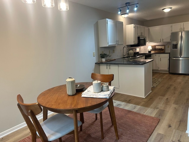 691 85th Ln NW Unit 1, Coon Rapids, MN 55433 - kitchen with appliances with stainless steel finishes, dark countertops, and light wood finished floors