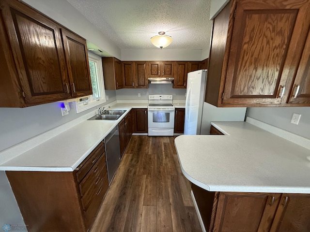1303 Duluth Ave N, Thief River Falls, MN 56701 - kitchen featuring white appliances, under cabinet range hood, dark wood-style flooring, light countertops, and a textured ceiling