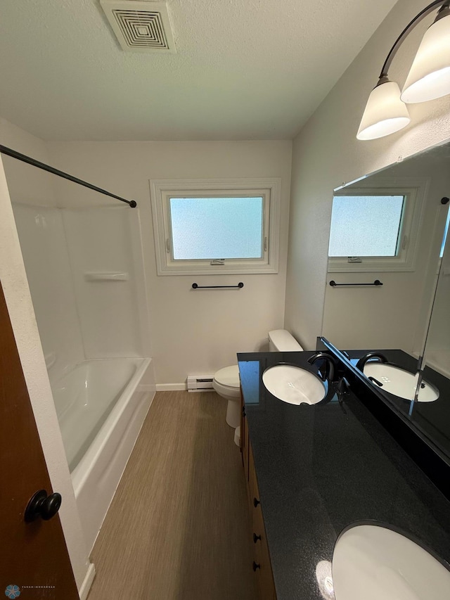 1303 Duluth Ave N, Thief River Falls, MN 56701 - bathroom with vanity, washtub / shower combination, a baseboard heating unit, and a textured ceiling