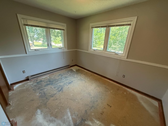 1303 Duluth Ave N, Thief River Falls, MN 56701 - empty room featuring a baseboard heating unit and healthy amount of natural light