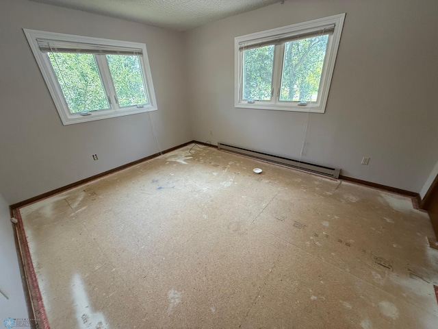 1303 Duluth Ave N, Thief River Falls, MN 56701 - empty room with a baseboard heating unit and a textured ceiling