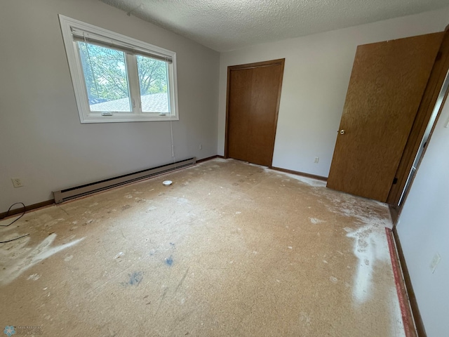 1303 Duluth Ave N, Thief River Falls, MN 56701 - unfurnished bedroom featuring a baseboard heating unit, a closet, and a textured ceiling