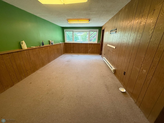 1303 Duluth Ave N, Thief River Falls, MN 56701 - spare room featuring a baseboard heating unit, wooden walls, carpet floors, a textured ceiling, and a wainscoted wall