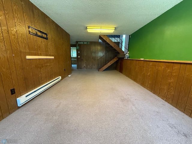 1303 Duluth Ave N, Thief River Falls, MN 56701 - below grade area with baseboard heating, wooden walls, carpet, a textured ceiling, and stairs