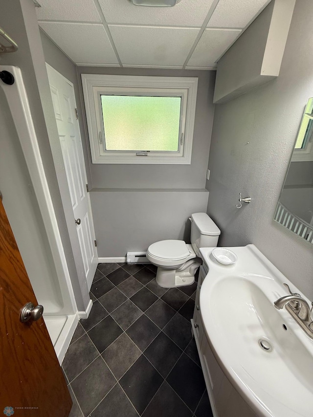 1303 Duluth Ave N, Thief River Falls, MN 56701 - bathroom with a baseboard heating unit, tile patterned floors, a stall shower, a drop ceiling, and vanity