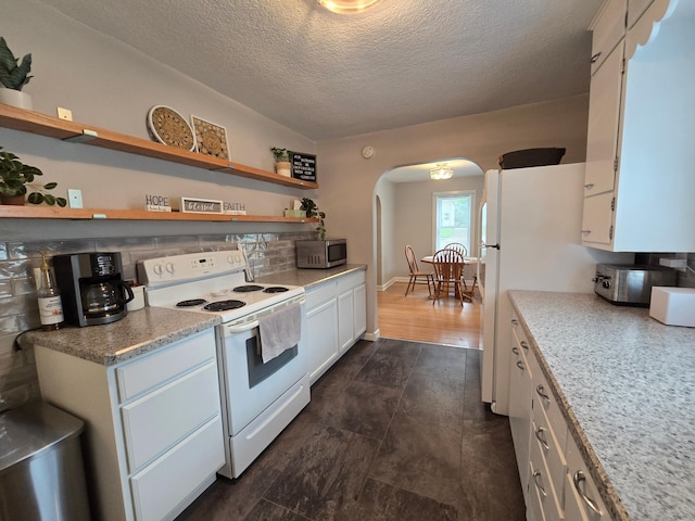818 Kenwood St, Alexandria, MN 56308 - kitchen with white appliances, arched walkways, white cabinets, a textured ceiling, and light countertops
