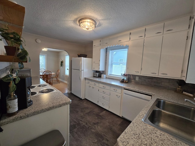 818 Kenwood St, Alexandria, MN 56308 - kitchen with white appliances, arched walkways, white cabinetry, plenty of natural light, and a textured ceiling