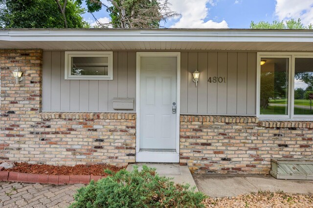 4801 Louisiana Ave N, Crystal, MN 55428 - view of exterior entry with brick siding and a porch
