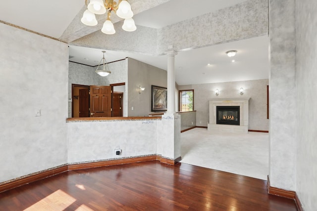 11228 River Rd, Champlin, MN 55316 - unfurnished living room featuring wood finished floors, a chandelier, ornate columns, high vaulted ceiling, and a glass covered fireplace