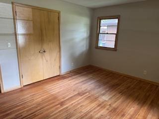 11721 Olive St NW, Coon Rapids, MN 55448 - unfurnished bedroom with wood finished floors and a closet