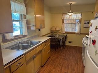 11721 Olive St NW, Coon Rapids, MN 55448 - kitchen featuring freestanding refrigerator, wood finished floors, light countertops, pendant lighting, and brown cabinetry