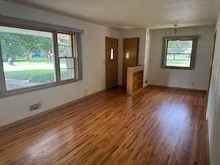 11721 Olive St NW, Coon Rapids, MN 55448 - unfurnished living room with wood finished floors and baseboards
