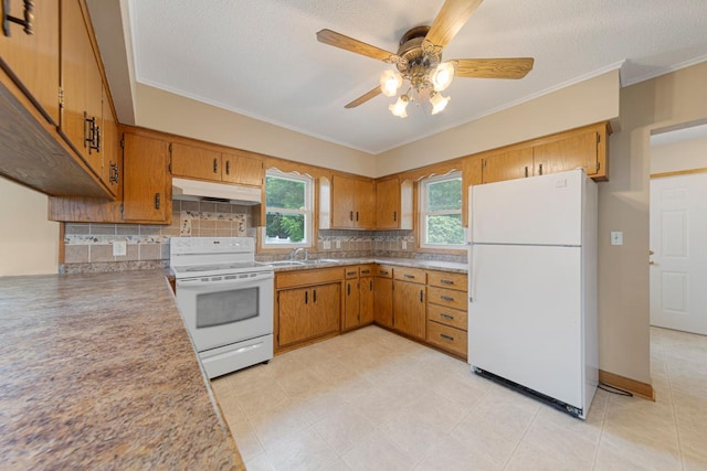 215 Plainview St, Owatonna, MN 55060 - kitchen with white appliances, under cabinet range hood, brown cabinetry, a ceiling fan, and crown molding