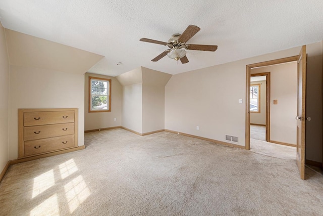 215 Plainview St, Owatonna, MN 55060 - bonus room with ceiling fan, a textured ceiling, light colored carpet, and vaulted ceiling