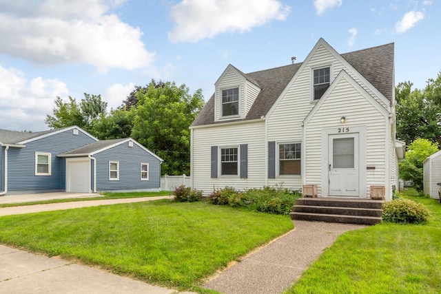 215 Plainview St, Owatonna, MN 55060 - new england style home with a shingled roof, a garage, and an outbuilding