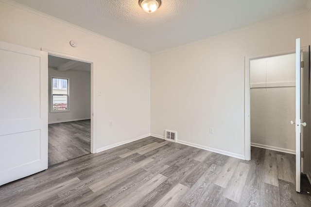 1826 Case Ave E, Saint Paul, MN 55119 - unfurnished bedroom featuring ornamental molding, wood finished floors, and a textured ceiling
