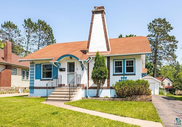 1718 Dunedin Ave, Duluth, MN 55803 - view of front of property with a chimney, stucco siding, a front yard, and roof with shingles