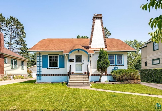1718 Dunedin Ave, Duluth, MN 55803 - view of front of property with a chimney, a front lawn, stucco siding, and roof with shingles