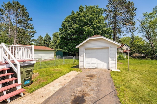 1718 Dunedin Ave, Duluth, MN 55803 - detached garage featuring driveway and view of wooded area
