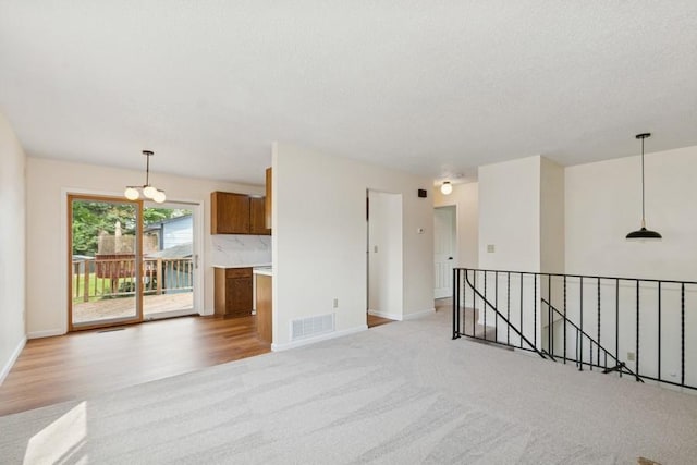 8983 Vinewood Ln N, Maple Grove, MN 55369 - unfurnished room featuring light colored carpet, a chandelier, and light wood-style floors