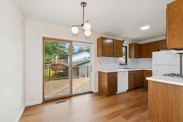 8983 Vinewood Ln N, Maple Grove, MN 55369 - kitchen with light wood finished floors, white appliances, a chandelier, brown cabinetry, and light countertops