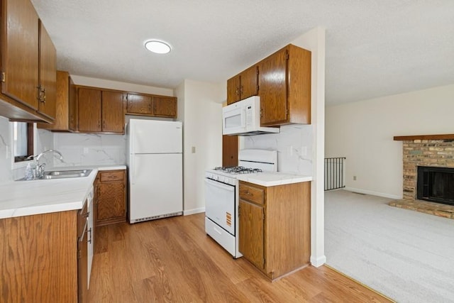 8983 Vinewood Ln N, Maple Grove, MN 55369 - kitchen with white appliances, brown cabinetry, light wood-type flooring, light countertops, and open floor plan