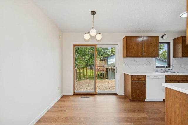 8983 Vinewood Ln N, Maple Grove, MN 55369 - kitchen featuring light countertops, healthy amount of natural light, dishwasher, and tasteful backsplash