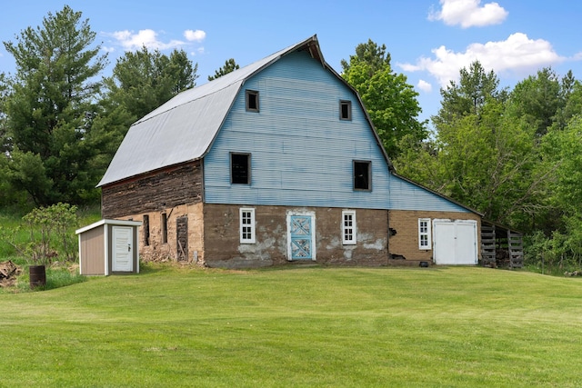 18400 Lundgren Dr, Pine Lake Twp, MN 55735 - back of property with a barn, a lawn, an outdoor structure, stone siding, and a gambrel roof