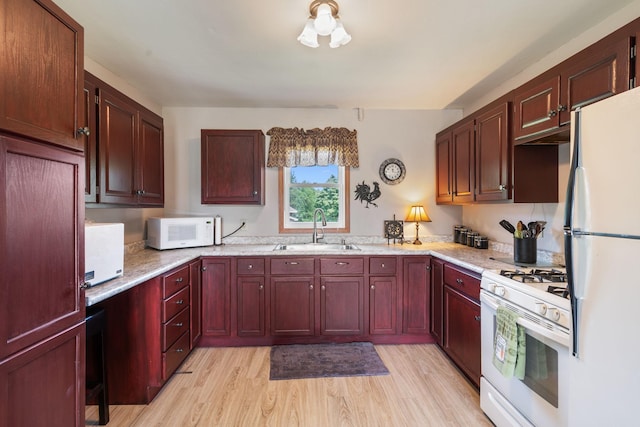 18400 Lundgren Dr, Pine Lake Twp, MN 55735 - kitchen featuring white appliances, reddish brown cabinets, light wood finished floors, and light stone counters