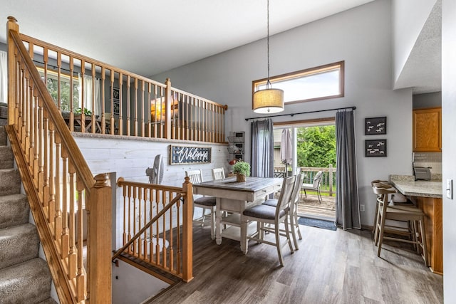 5830 Forest Boulevard Trl, Wyoming, MN 55092 - dining room featuring a towering ceiling, wood finished floors, and stairway