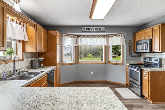 5830 Forest Boulevard Trl, Wyoming, MN 55092 - kitchen with appliances with stainless steel finishes, wood finished floors, healthy amount of natural light, light countertops, and a textured ceiling