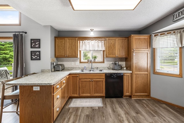 5830 Forest Boulevard Trl, Wyoming, MN 55092 - kitchen with black dishwasher, a peninsula, wood finished floors, light countertops, and backsplash