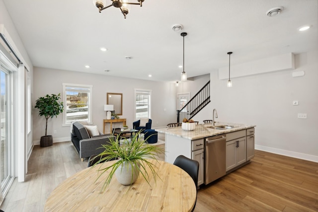 3401 Douglas Dr N, Crystal, MN 55422 - kitchen with stainless steel dishwasher, light wood finished floors, recessed lighting, a kitchen island with sink, and light stone countertops