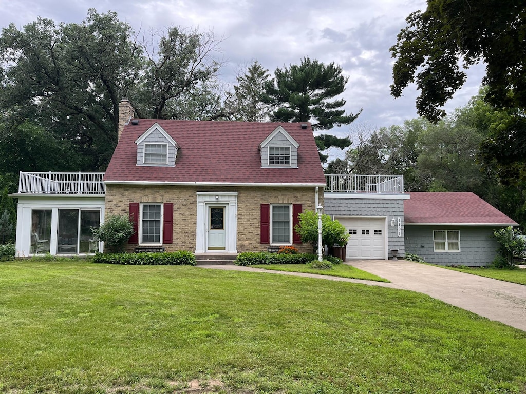 1401 2nd Ave, Newport, MN 55055 - new england style home with a balcony, a front yard, a chimney, and an attached garage