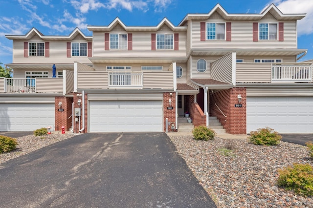 886 Coon Rapids Boulevard Extension NW, Coon Rapids, MN 55433 - traditional-style house featuring a garage, driveway, brick siding, and a balcony