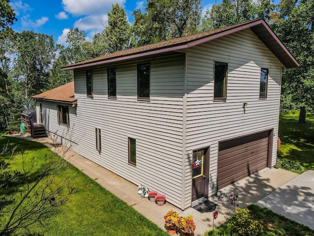 31879 US-71, Park Rapids, MN 56470 - view of property exterior featuring driveway, a garage, roof with shingles, and a yard