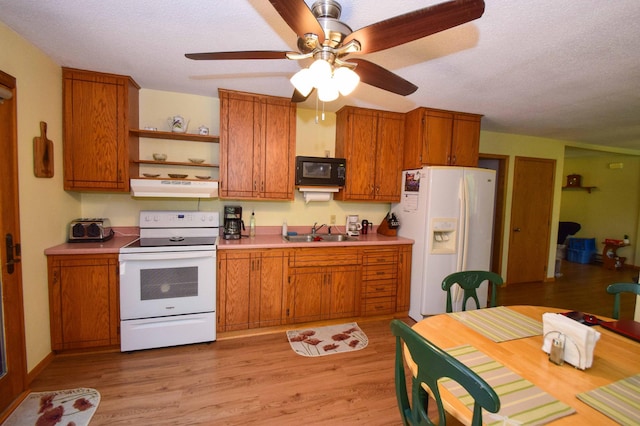 31879 US-71, Park Rapids, MN 56470 - kitchen with white appliances, under cabinet range hood, brown cabinets, light wood-type flooring, and a textured ceiling