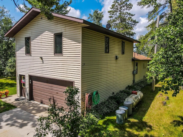 31879 US-71, Park Rapids, MN 56470 - view of side of home with an attached garage, concrete driveway, and a lawn