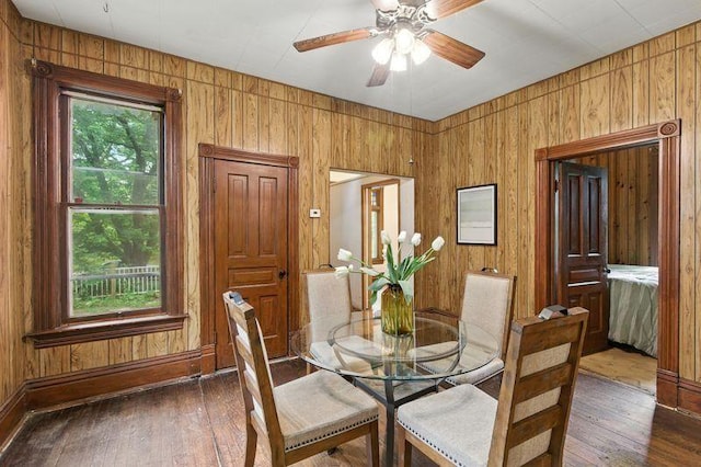 697 Tuscarora Ave, Saint Paul, MN 55102 - dining area with dark wood-style floors, wood walls, and ceiling fan