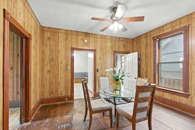 697 Tuscarora Ave, Saint Paul, MN 55102 - dining room with hardwood / wood-style floors, wood walls, and a ceiling fan