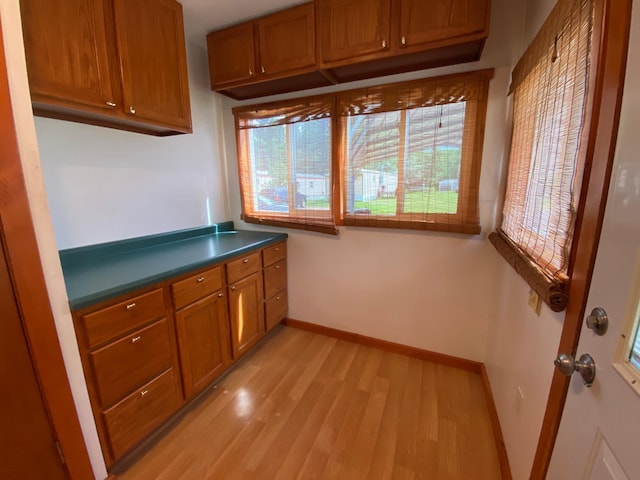 225 Jay St Unit 12, Sandstone, MN 55072 - kitchen featuring brown cabinetry, light wood finished floors, and dark countertops