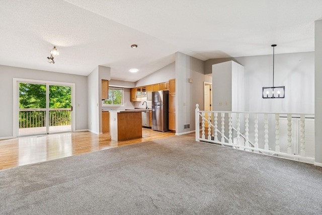 551 Townes Rd, Minnetonka, MN 55391 - unfurnished living room featuring light carpet, a chandelier, lofted ceiling, and light wood-style flooring