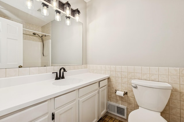 551 Townes Rd, Minnetonka, MN 55391 - bathroom with tile walls, vanity, a shower, a wainscoted wall, and tile patterned floors