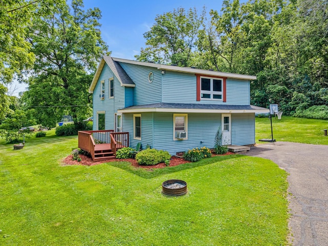 1273 County Rd N, Kinnickinnic Twp, WI 54023 - view of front of house featuring a wooden deck, an outdoor fire pit, asphalt driveway, a front lawn, and a shingled roof